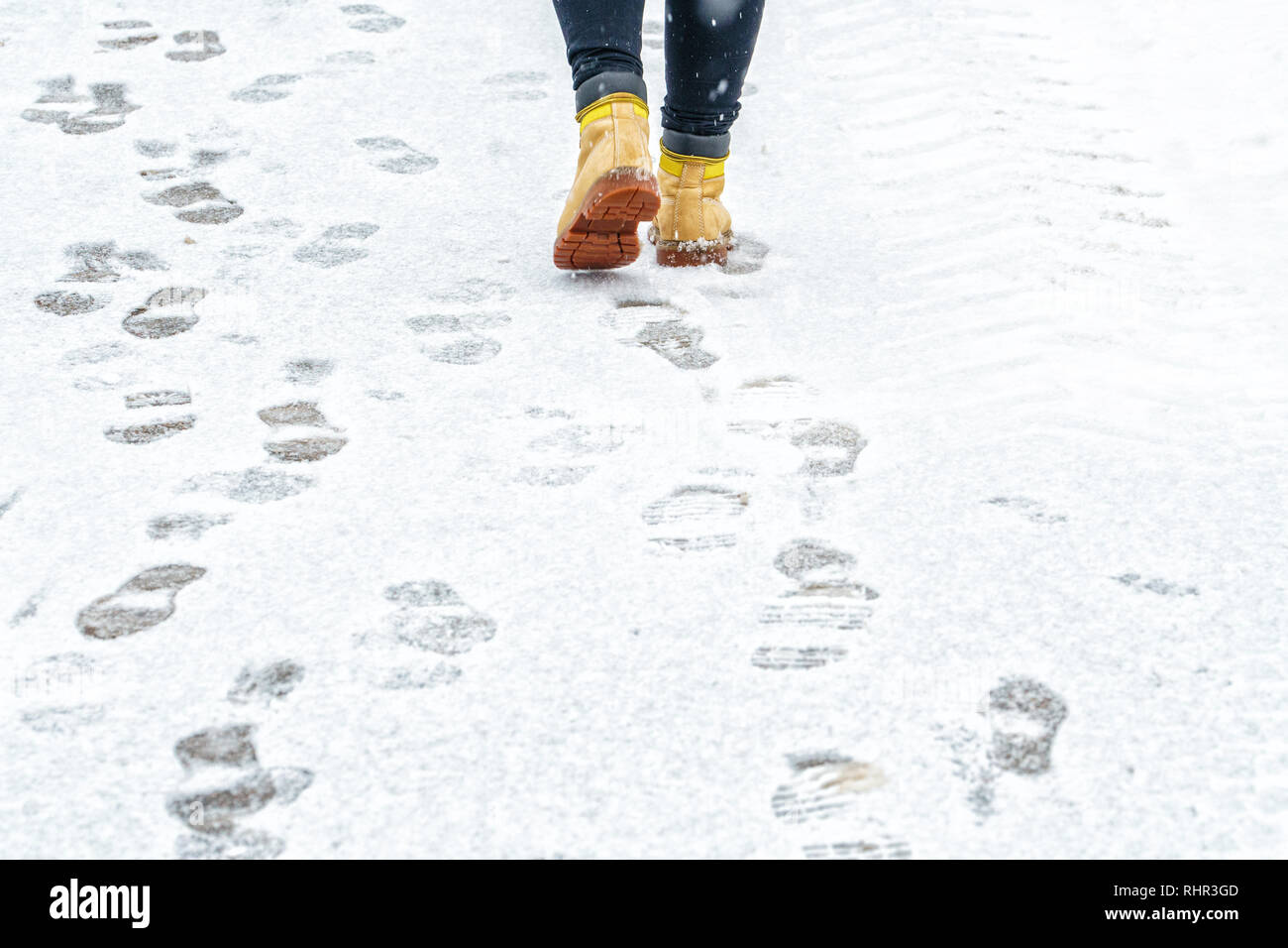 Winter Walk in Yellow Leather Boots. Back view on the feet of a man