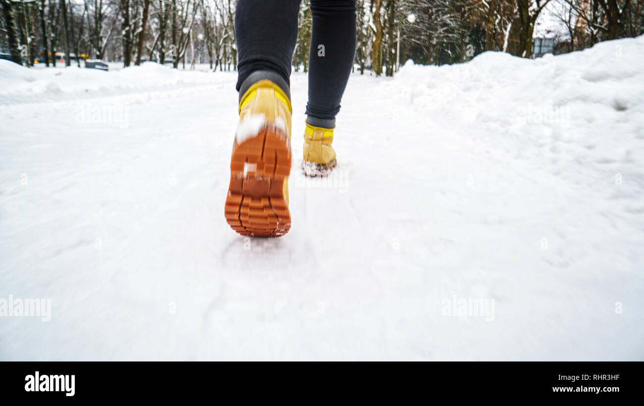 Winter Walk in Yellow Leather Boots. Back view on the feet of a man