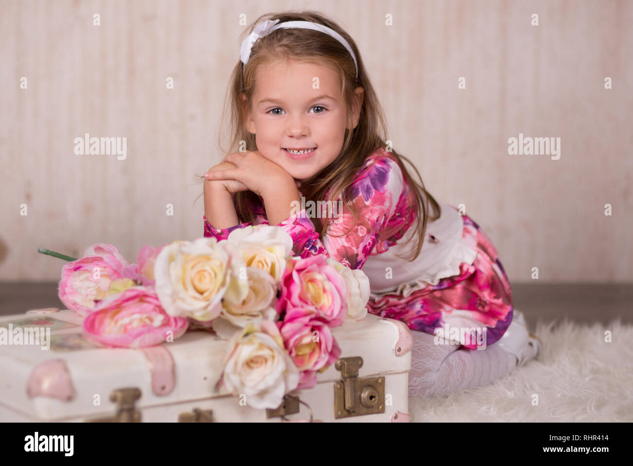 Cute baby girl with brunette hairs pink cheeks and green eyes posing sit  for camera in studio wearing airy colourful dress and fancy casuals pumps  clo Stock Photo - Alamy
