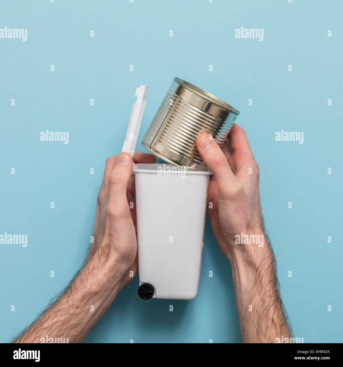 Recycle metal. Hands putting tin can into a bin Stock Photo Alamy
