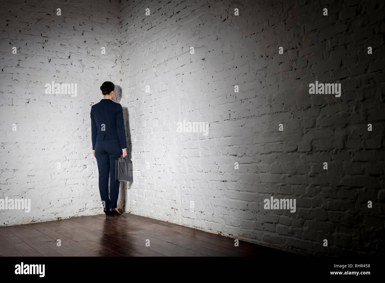 Full length rear view of businesswoman standing in corner at office Stock Photo