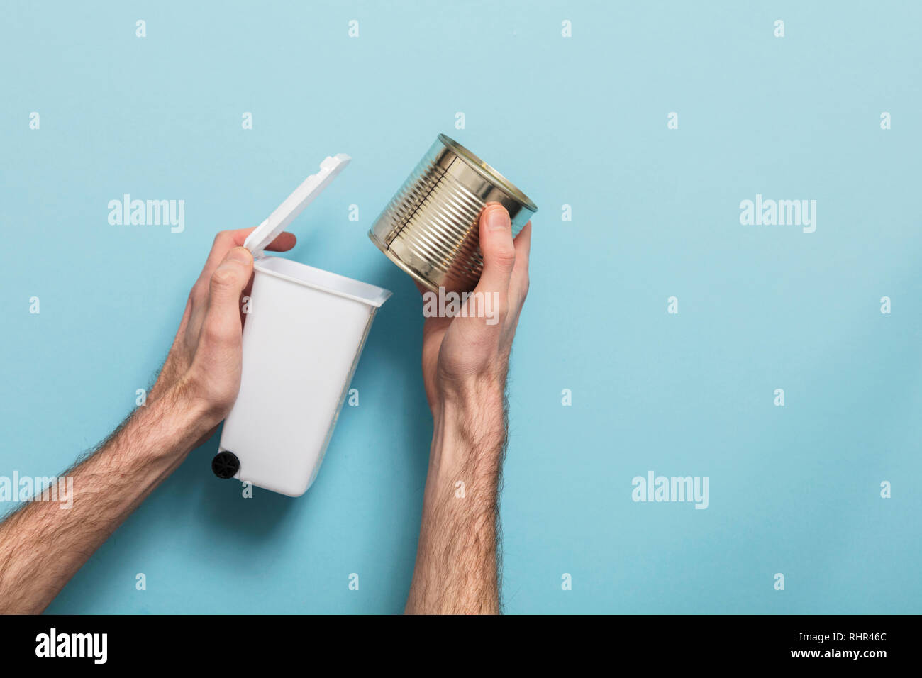 Recycle metal. Hands putting tin can into a bin Stock Photo Alamy
