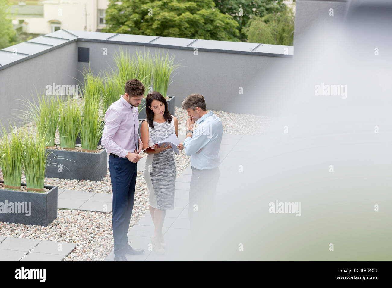 High angle view of colleagues discussing over documents at office terrace Stock Photo