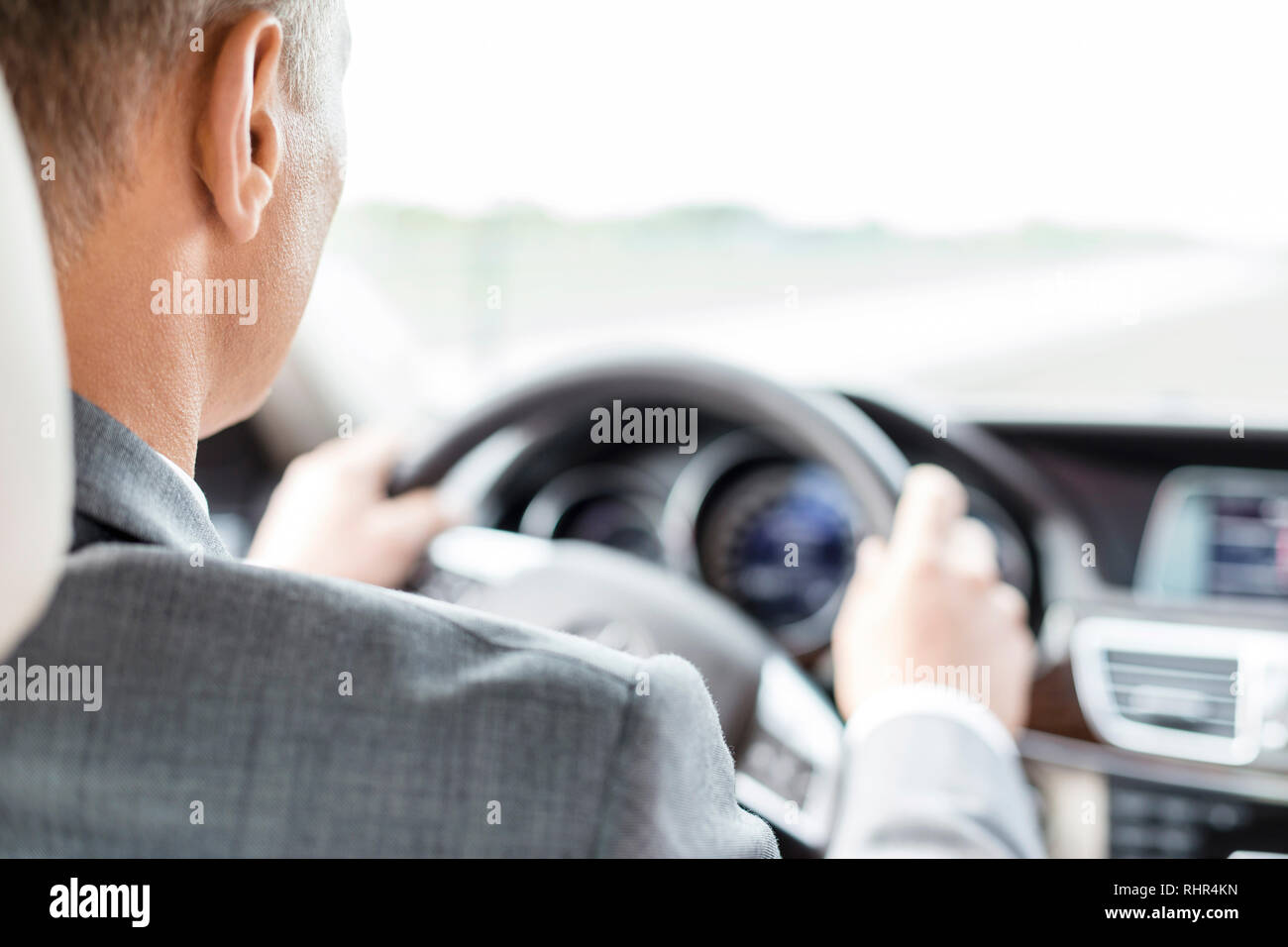 Business executive in suit driving car Stock Photo