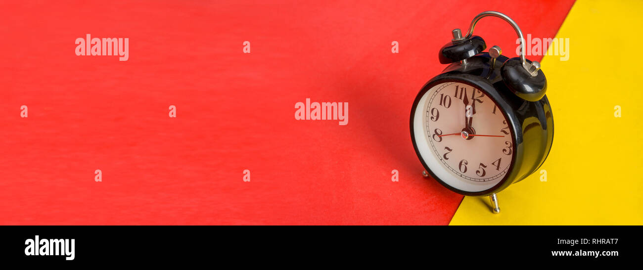 Black table clock on yellow and red banner template Stock Photo - Alamy