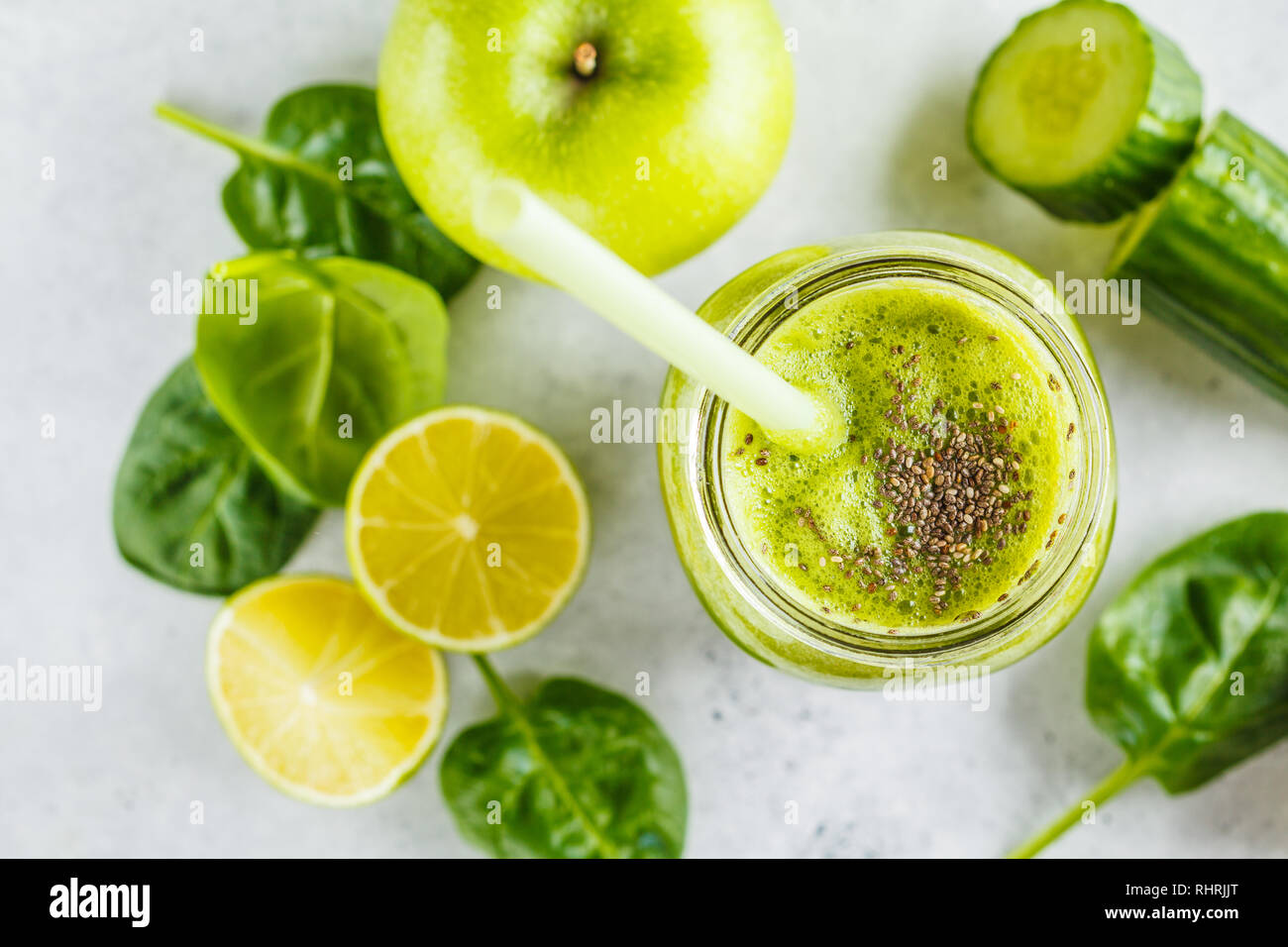 Green healthy smoothie (juice) in the jar. Apple, spinach, cucumber smoothie on a white background with the ingredients. Stock Photo
