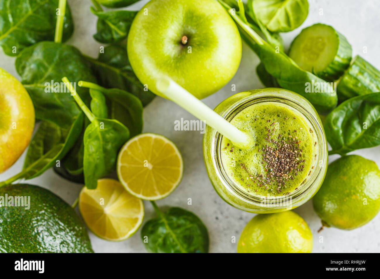 Green healthy smoothie (juice) in the jar. Apple, spinach, cucumber smoothie on a white background with the ingredients. Stock Photo