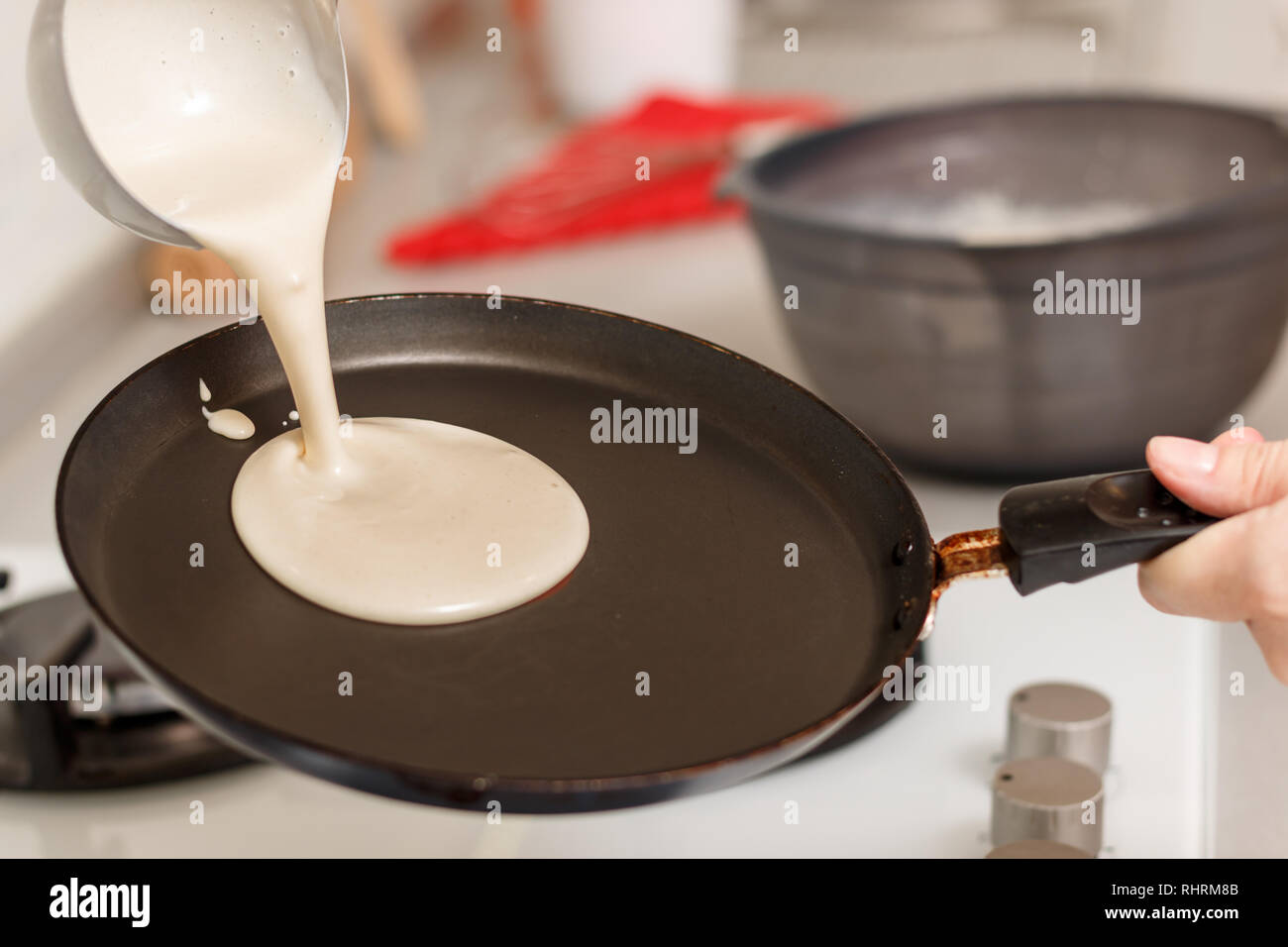 Closeup cooking pancakes on a gas stove. On a hot skillet liquid dough