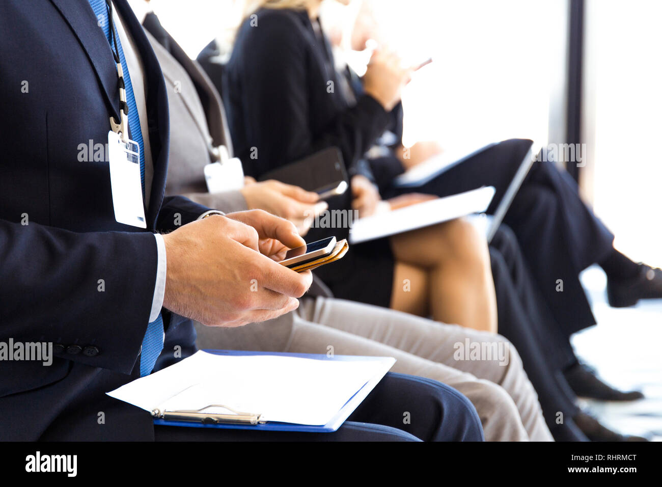 Business men using mobile phones sitting at training room, conference hall Stock Photo
