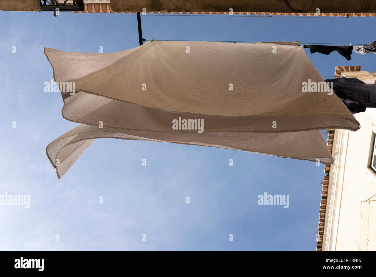 Pure white sheets hanging out to dry on a windy day on a washing line