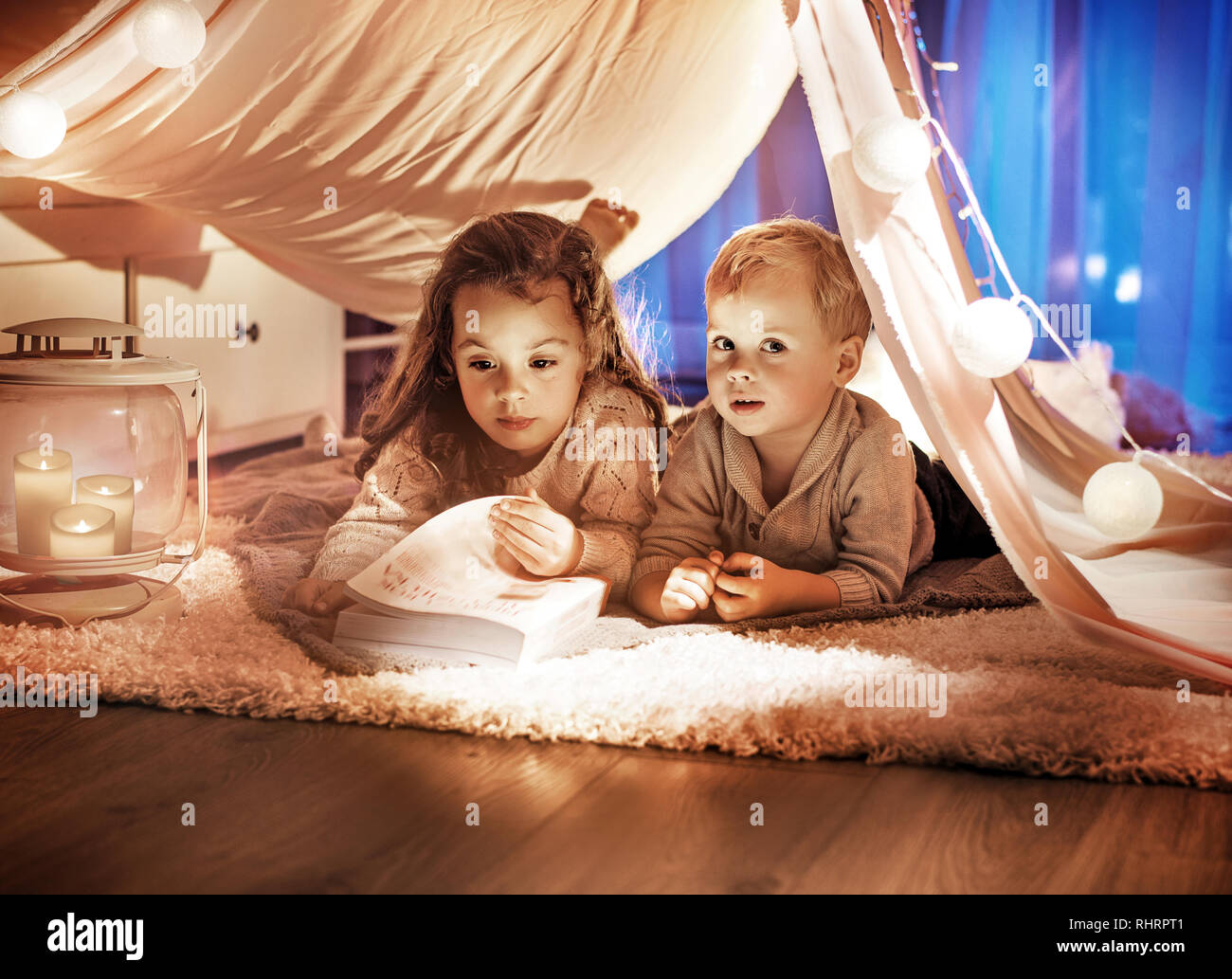 Portrait of cute brother and sister reading an interesting story Stock Photo