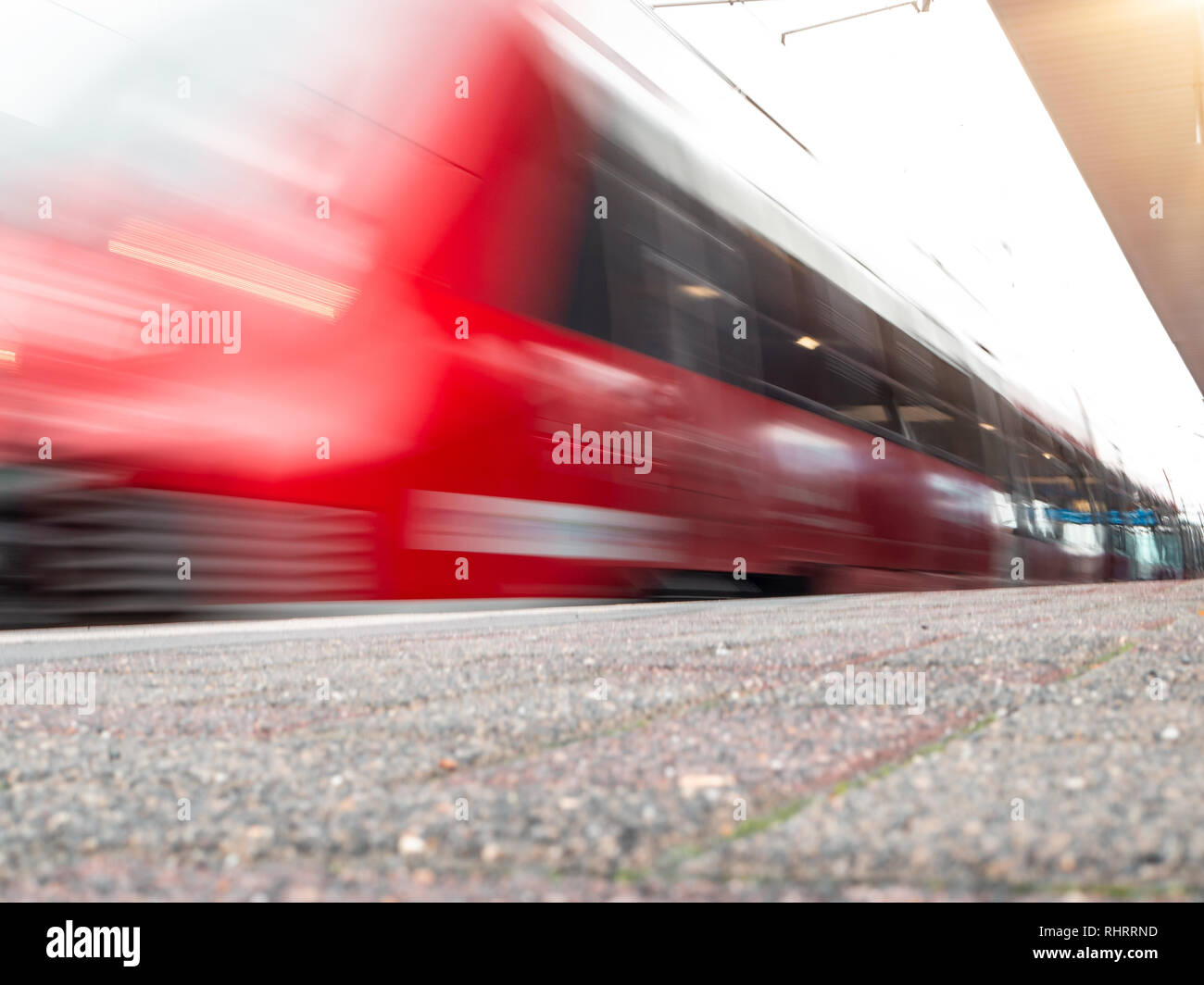 rail platform with red commuter train in motion blur in Cologne, Germany. Stock Photo