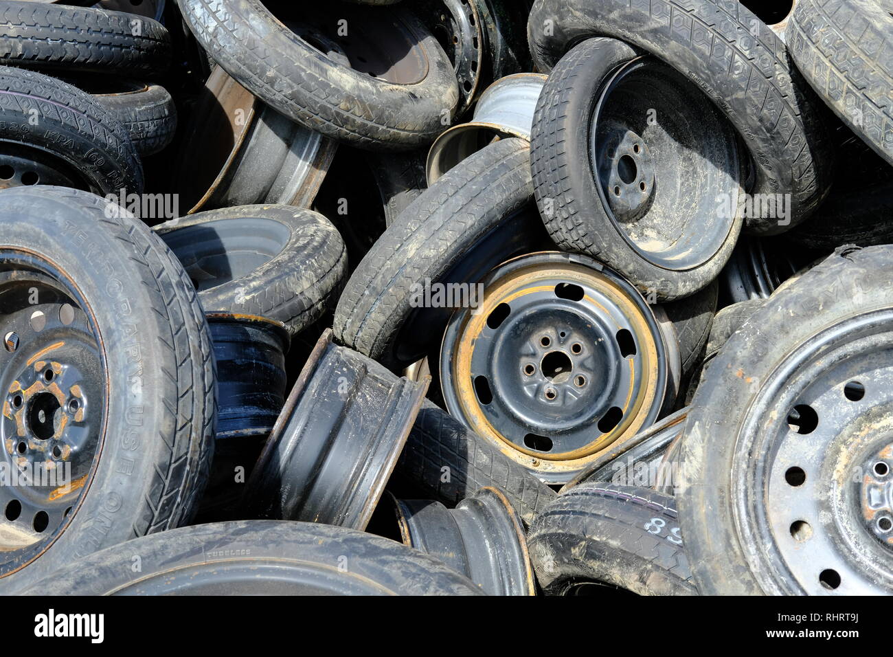 Randomly placed used or discarded tires with rims or wheels; Austin