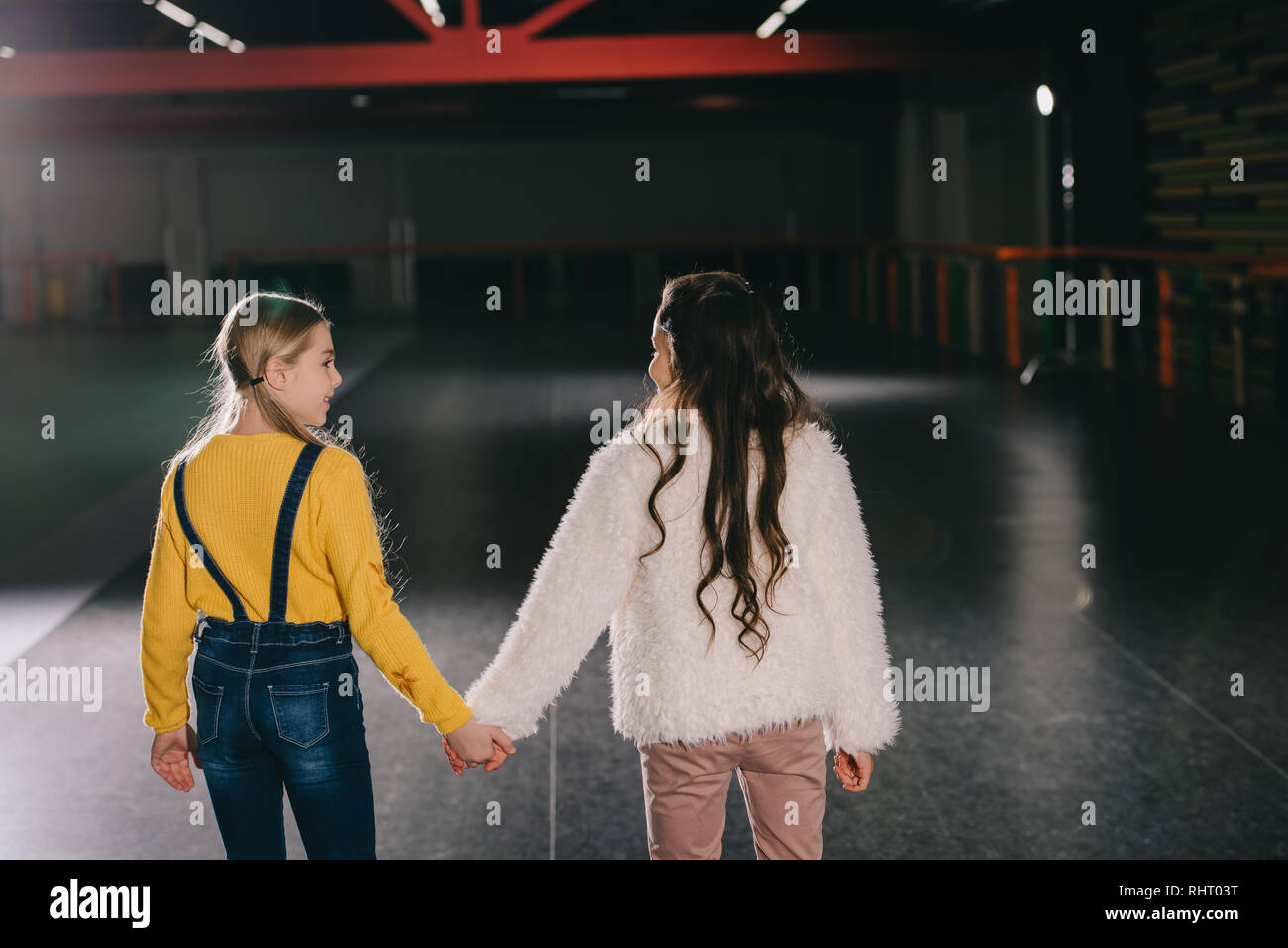 Two children holding hands looking hi-res stock photography and images ...