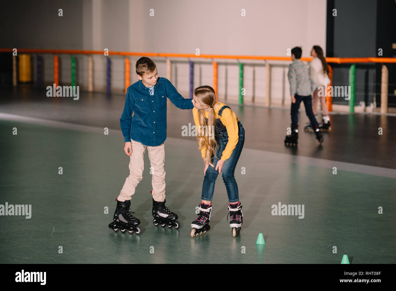 Joyful kids practicing roller skating on rink together Stock Photo