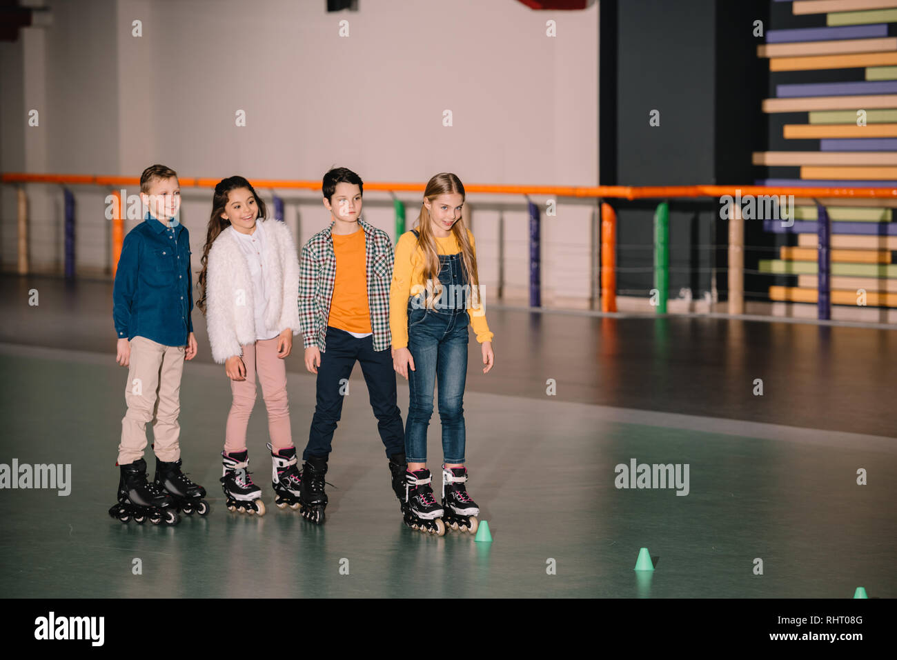Smiling cute kids ride roller skaters together Stock Photo
