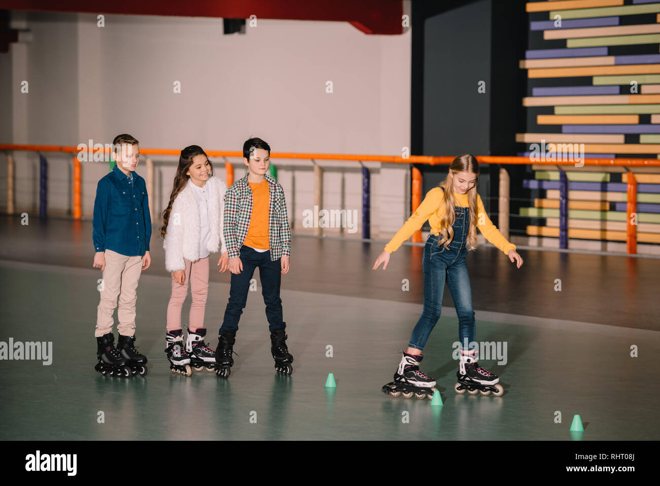 Adorable children skating on roller rink together Stock Photo