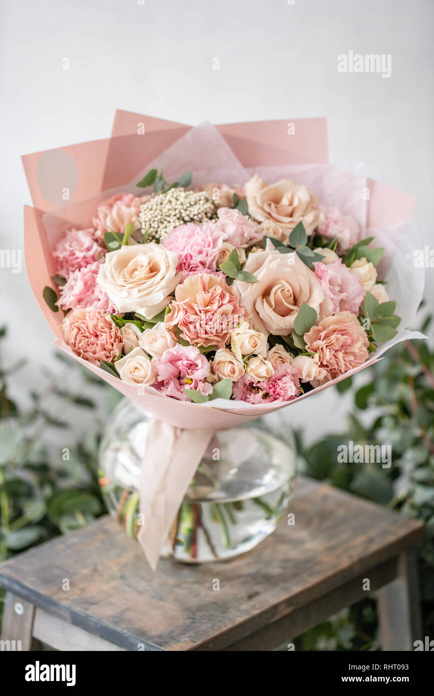 beautiful fresh cut bouquet of mixed flowers in vase on wooden table