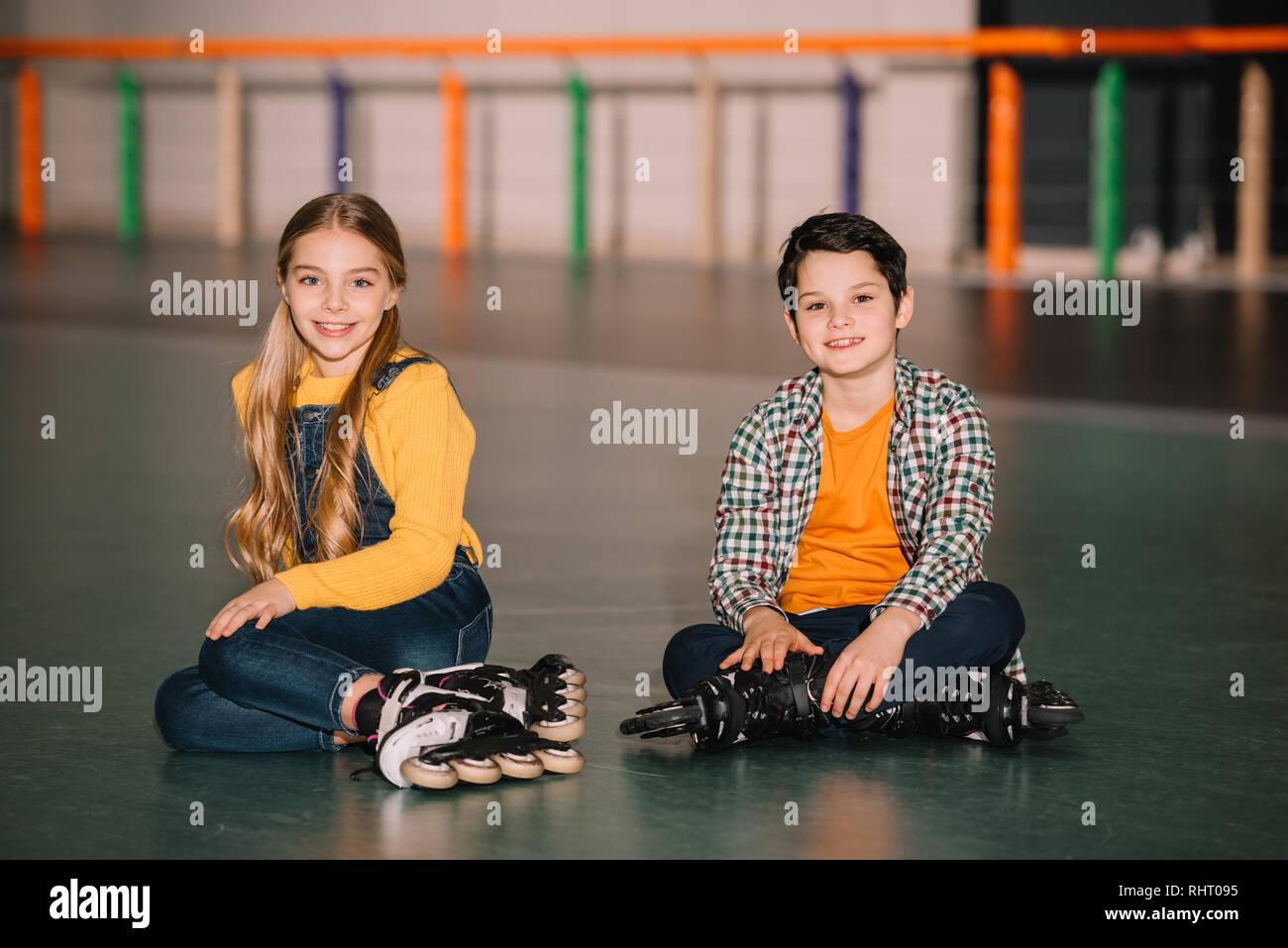 Indoor shot of smiling kids in roller skates having fun together Stock Photo