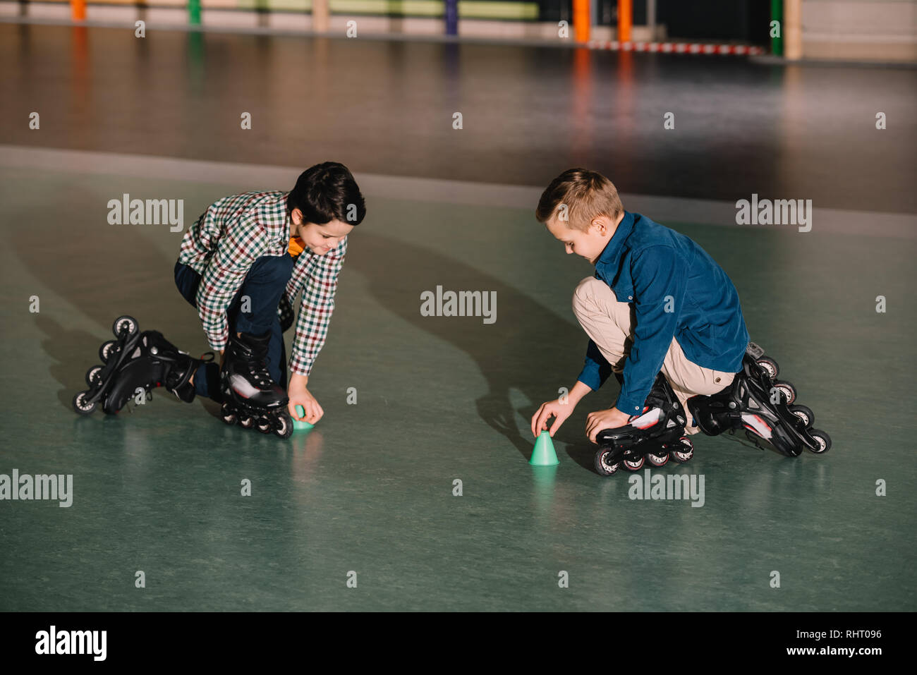Roller kids in black skates training together in gym Stock Photo