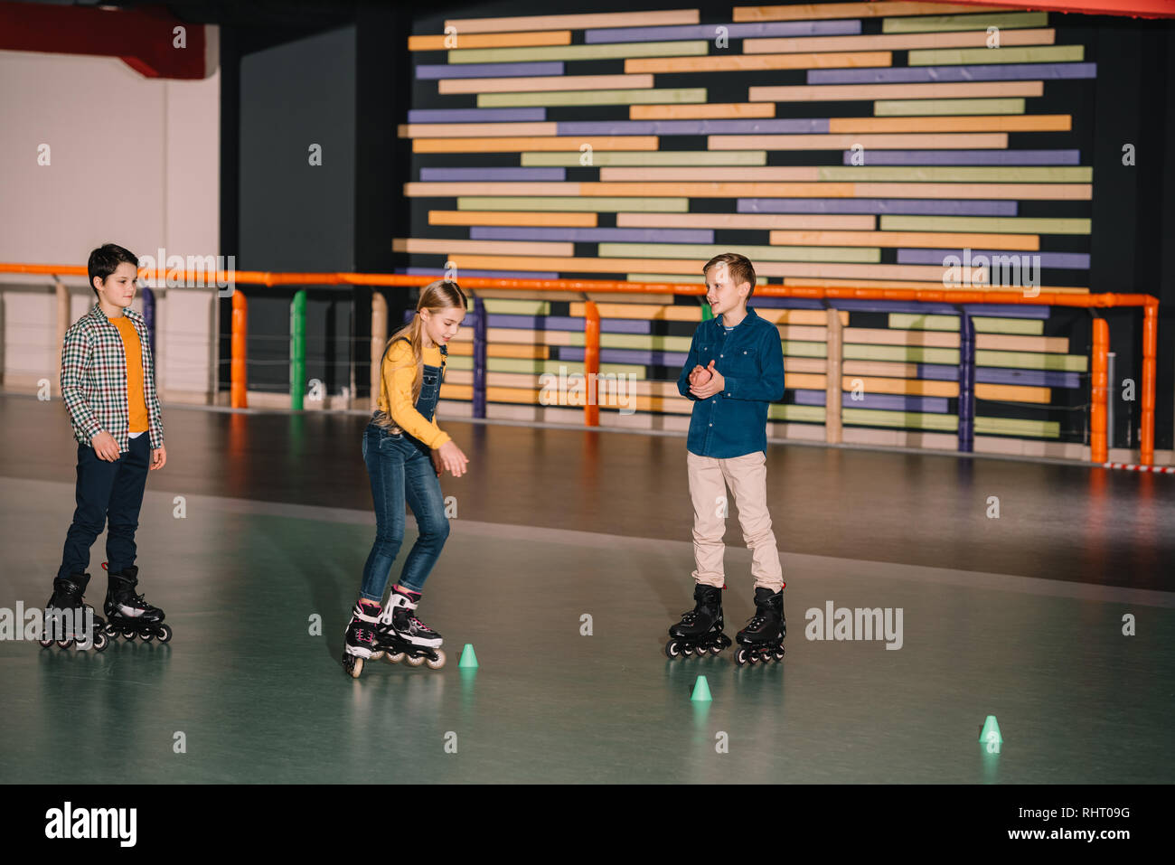 Preteen roller skaters practicing skating on rink together Stock Photo