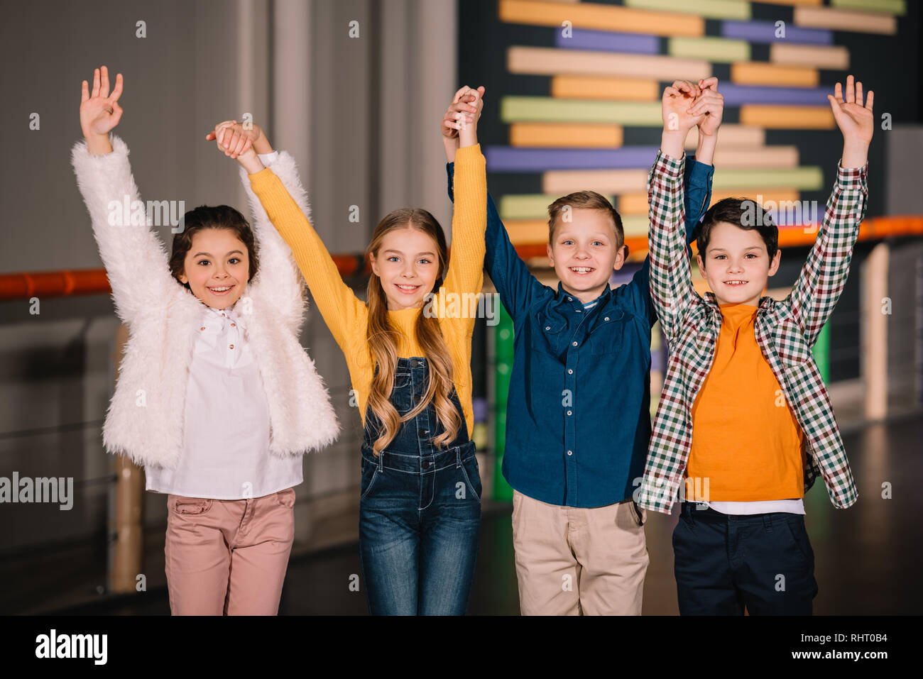 Children raising hands up and expressing happy emotions Stock Photo