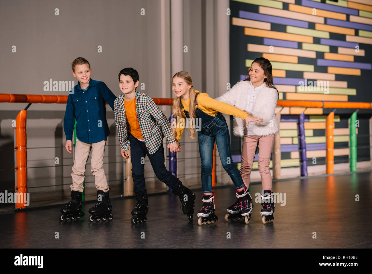 Full length shot of kids fooling around on skating rink Stock Photo