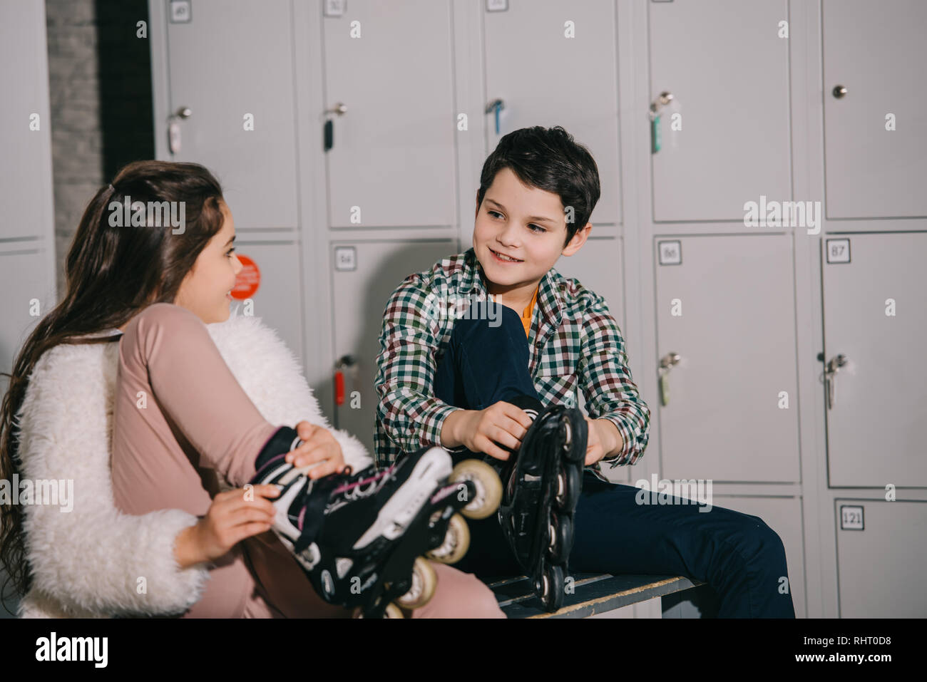 Kids in roller skates talking in locker room Stock Photo