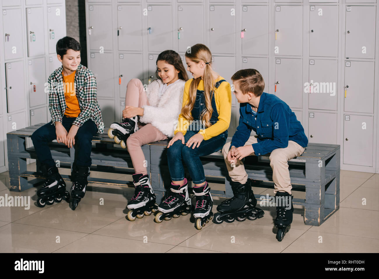 Group of kids in roller skates talking in changing room Stock Photo
