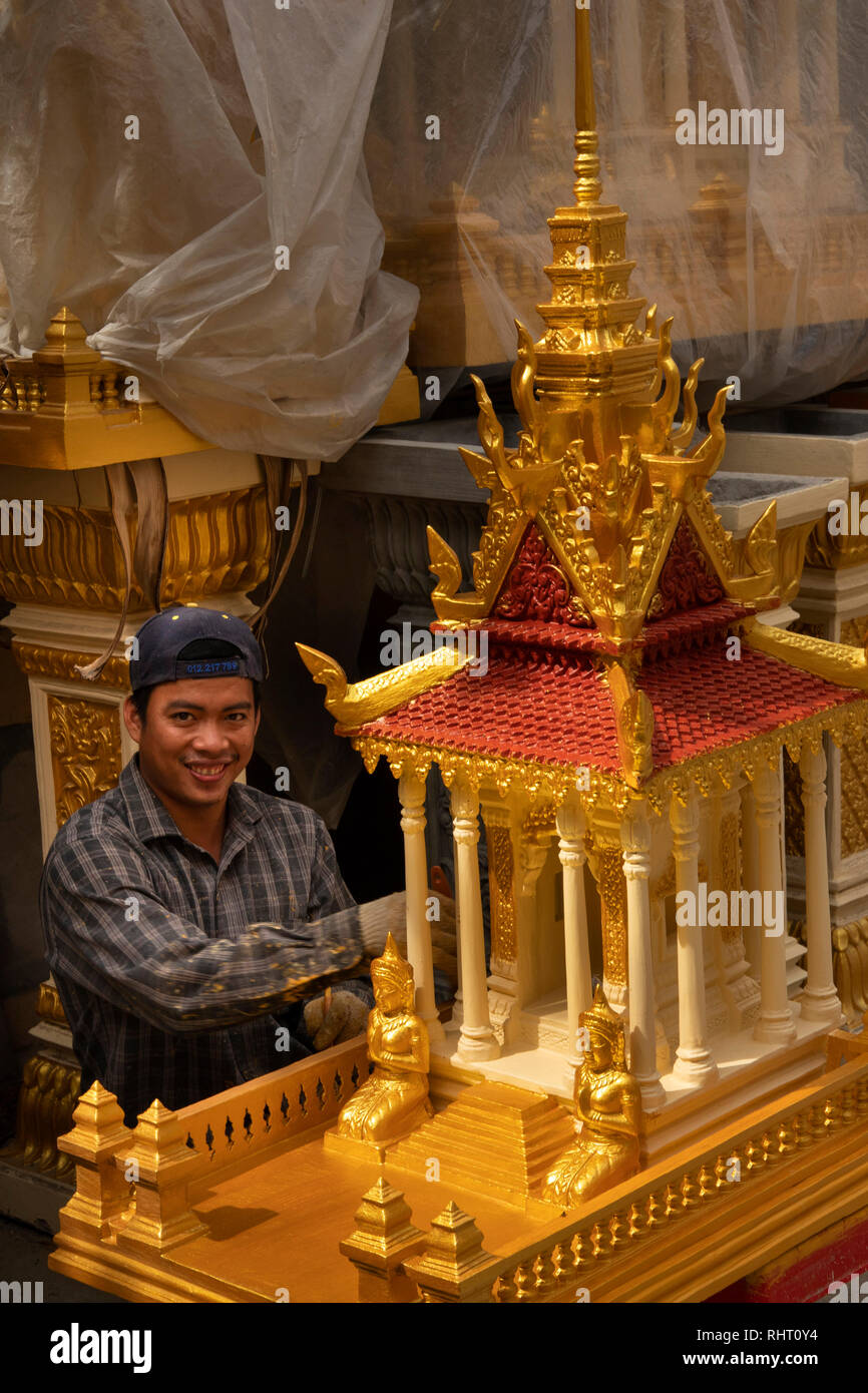 Cambodia, Phnom Penh, Street 305, worker painting new spirit house with gold paint Stock Photo