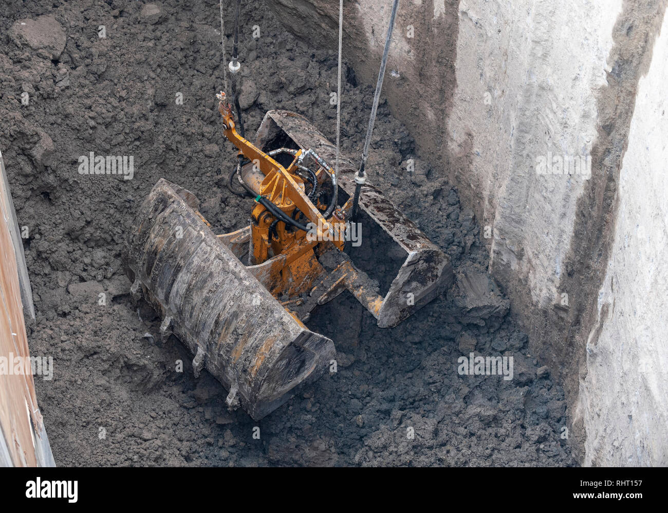 Construction site. A clamshell Dredge, go down to the open position, take and up, a full bucket of dirt. Stock Photo