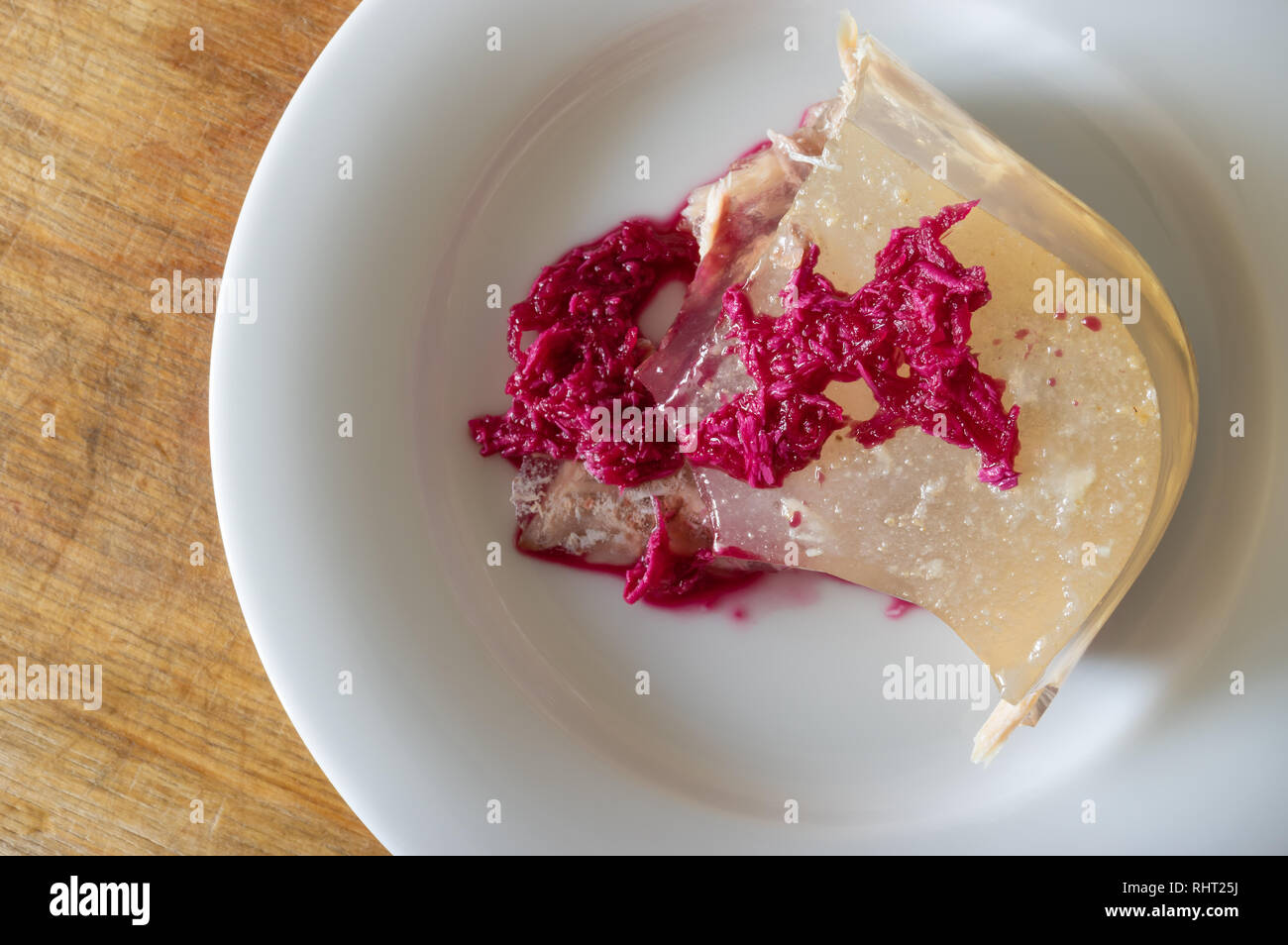 Top view on a plate with Ukrainian aspic flavoured with horse-radish pickled in beetroot juice Stock Photo