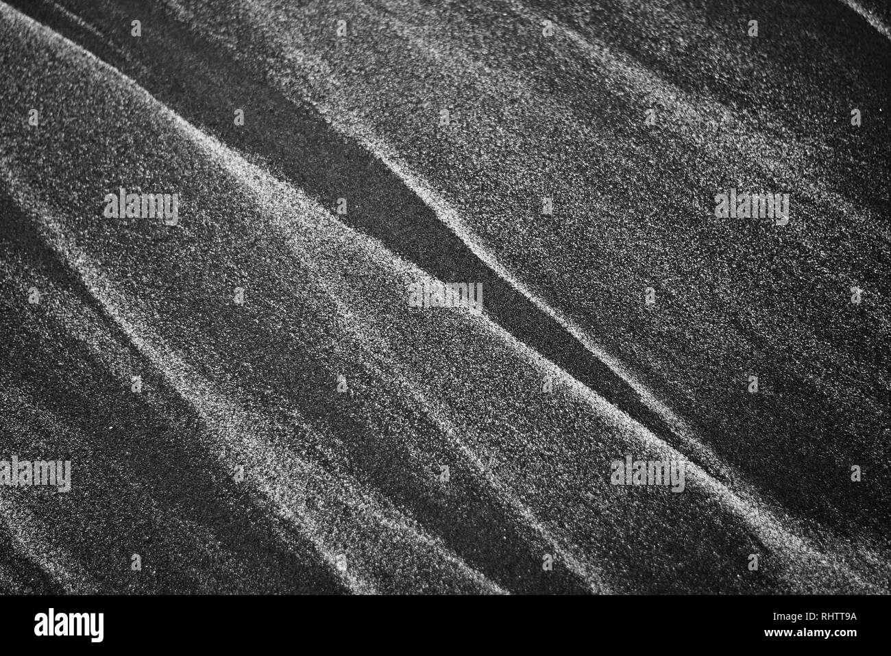 Abstract patterns made by waves on famous black sand of New Zealand ...