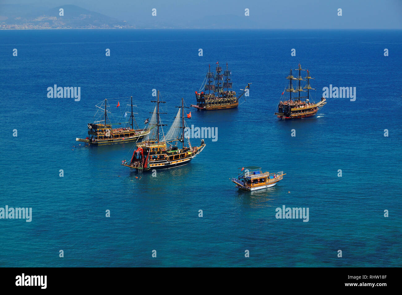 Tourist sail boats in turquoise waters of the Mediterranean sea beside 