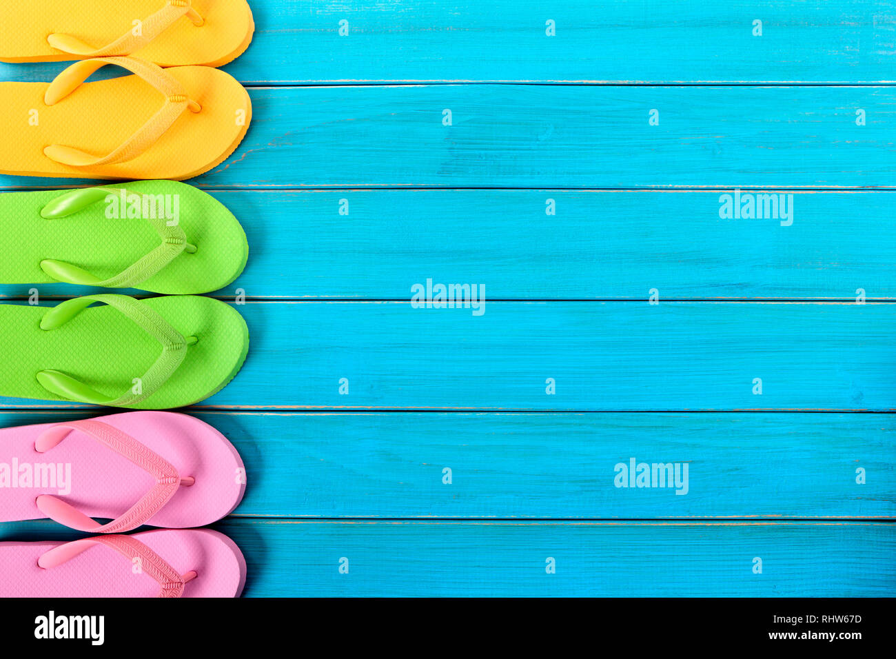 Side border row of flip-flops on blue background wood beach decking ...