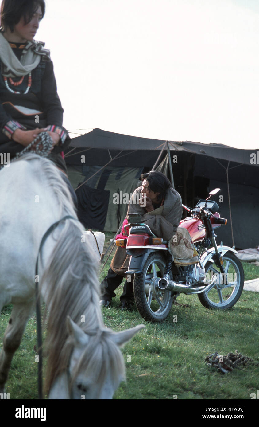 Nomads outside their tent on the Aba grasslands differ in their choice of transport. Stock Photo