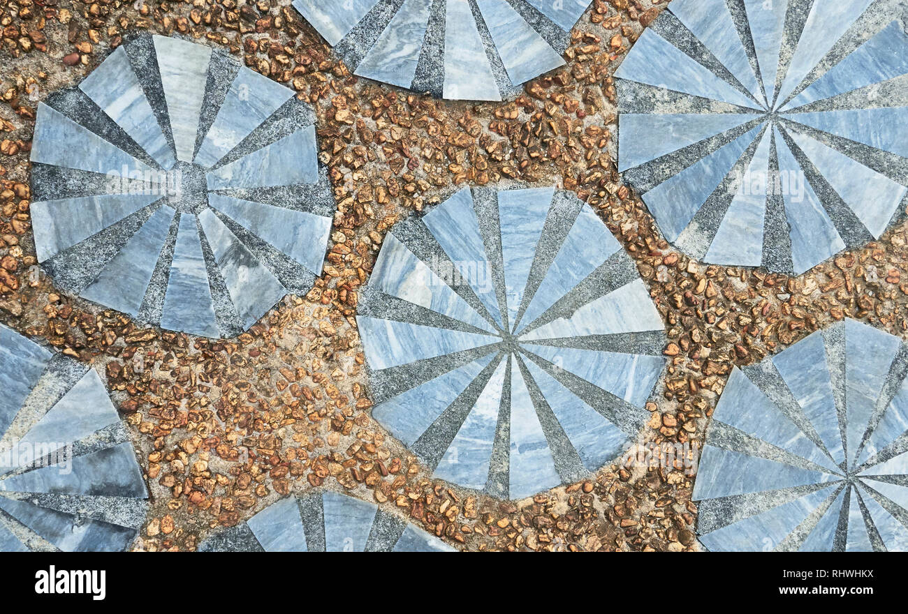 Ornamental-style of marble pieces, put together with concrete in round shapes, surrounded by gravel pathway flooring. Self-made style seen in Asia Stock Photo