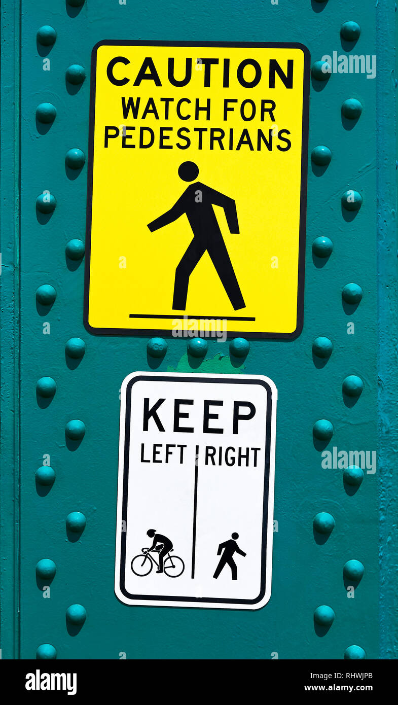 Close-up of a right yellow and white pedestrian warning street signage seen on Lion's Bridge in Vancouver, Canada Stock Photo