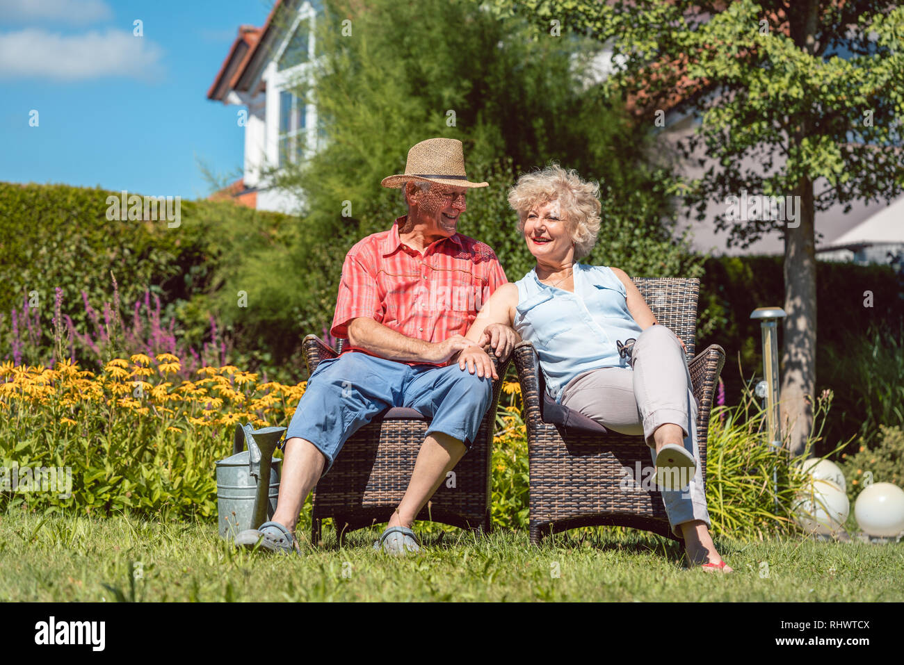 Happy senior couple in love relaxing together in the garden in summer Stock Photo