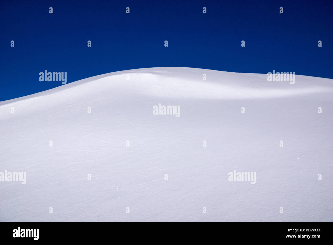 freshly fallen snow wall which looks like a wave in the Swiss Alps Stock Photo