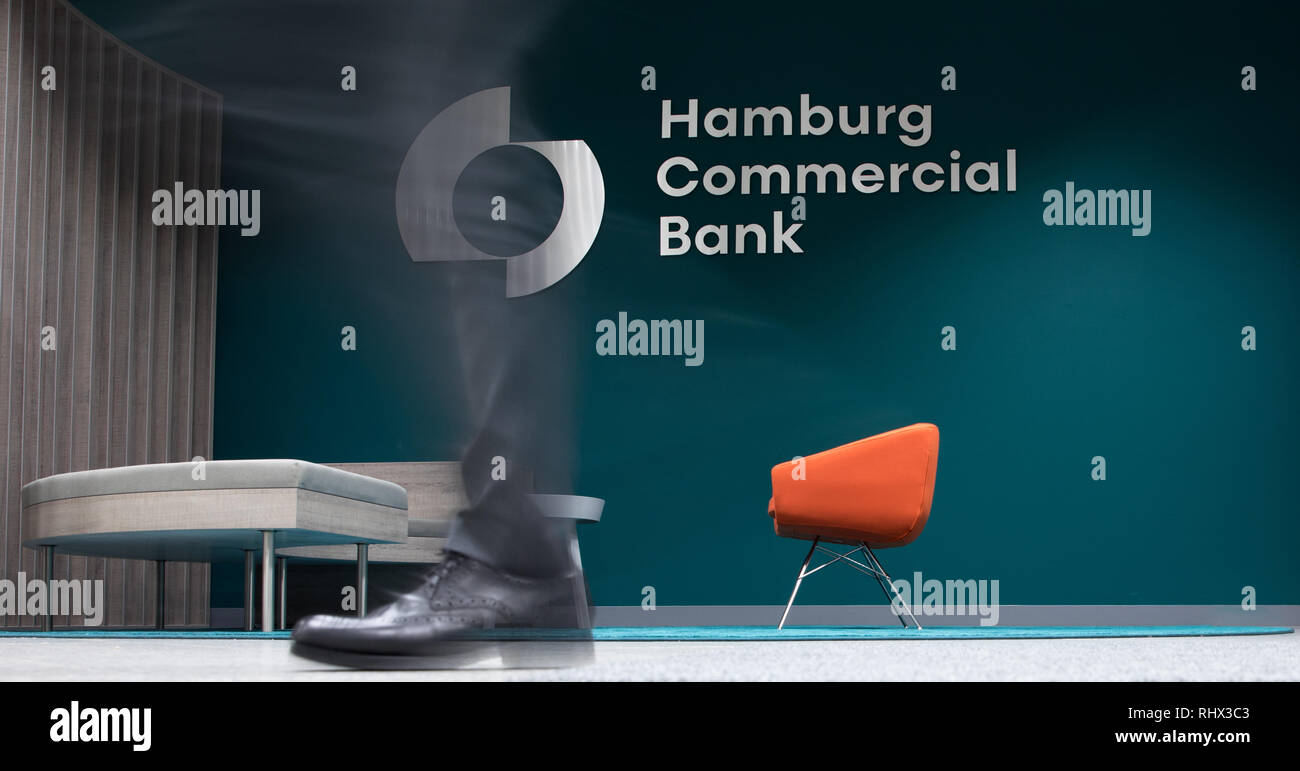 04 February 2019, Hamburg: A man walks through the foyer into the headquarters of Hamburg Commercial Bank (recording with long shutter speed). Two months after the privatisation, HSH Nordbank now officially bears the new name Hamburg Commercial Bank. The change of name to a private commercial bank was formally completed with the entry in the commercial registers of Hamburg and Kiel on Monday. Photo: Christian Charisius/dpa Stock Photo