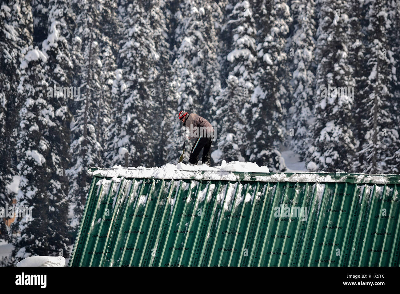 February 4, 2019 - Gulmarg, J&K, India - A Kashmiri man seen clearing snow from the roof of the hotel at a famous ski resort in Gulmarg, about 55kms from Srinagar, Indian administered Kashmir.Gulmarg, situated in the foothills of the Himalayas at 2,745 meters (9,000 feet) above sea level, is one of the leading ski destinations in South Asia. Credit: Saqib Majeed/SOPA Images/ZUMA Wire/Alamy Live News Stock Photo