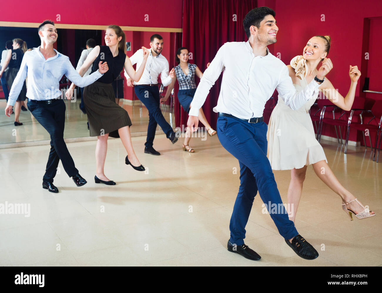 Young happy cheerful people dancing rock-and-roll in pairs Stock Photo ...