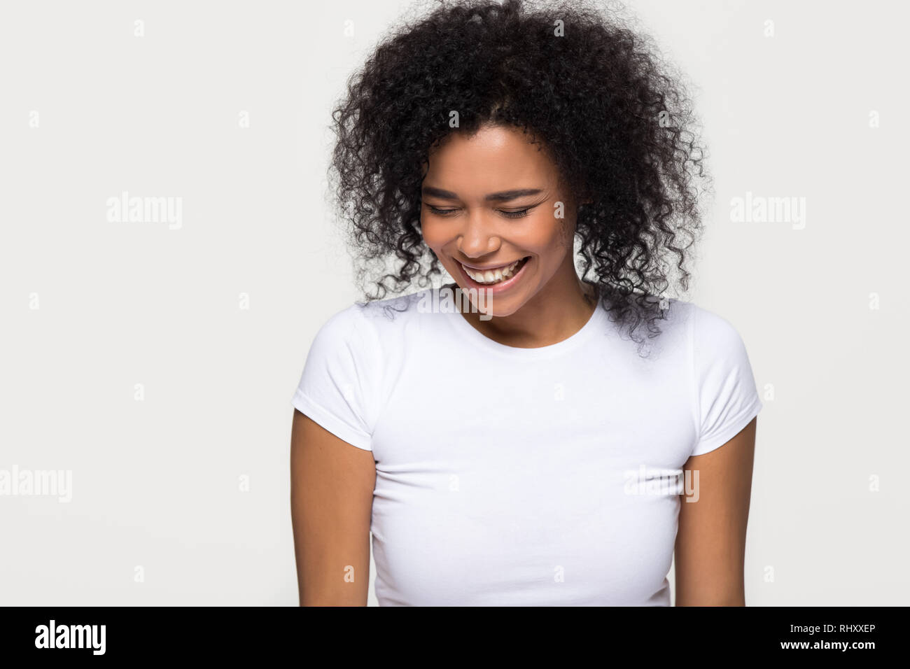 Cheerful black girl laughing isolated on white grey studio background Stock Photo
