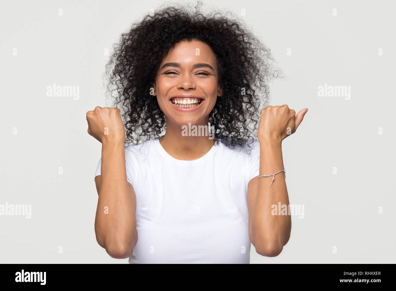 Excited happy african woman feeling overjoyed isolated at white background Stock Photo