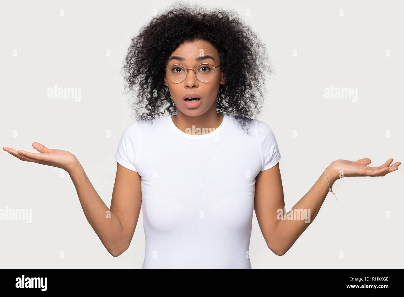 Confused doubtful baffled black woman shrugging looking at camera Stock Photo