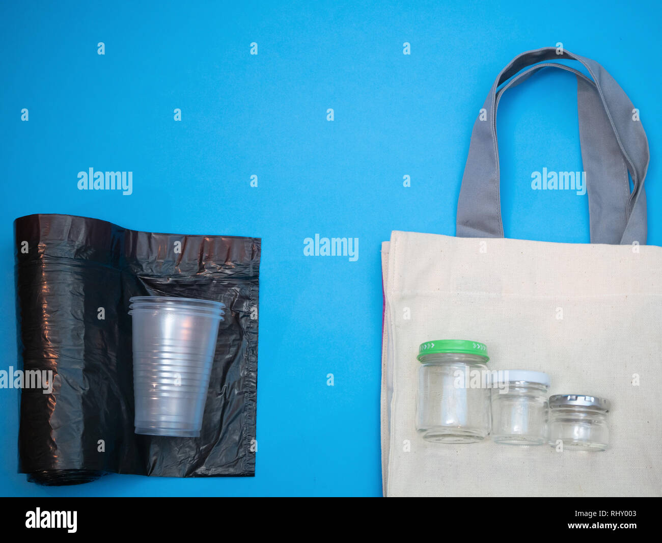 artificial vs natural materials concept. plastic cups on trash bags versus glass jars and linen