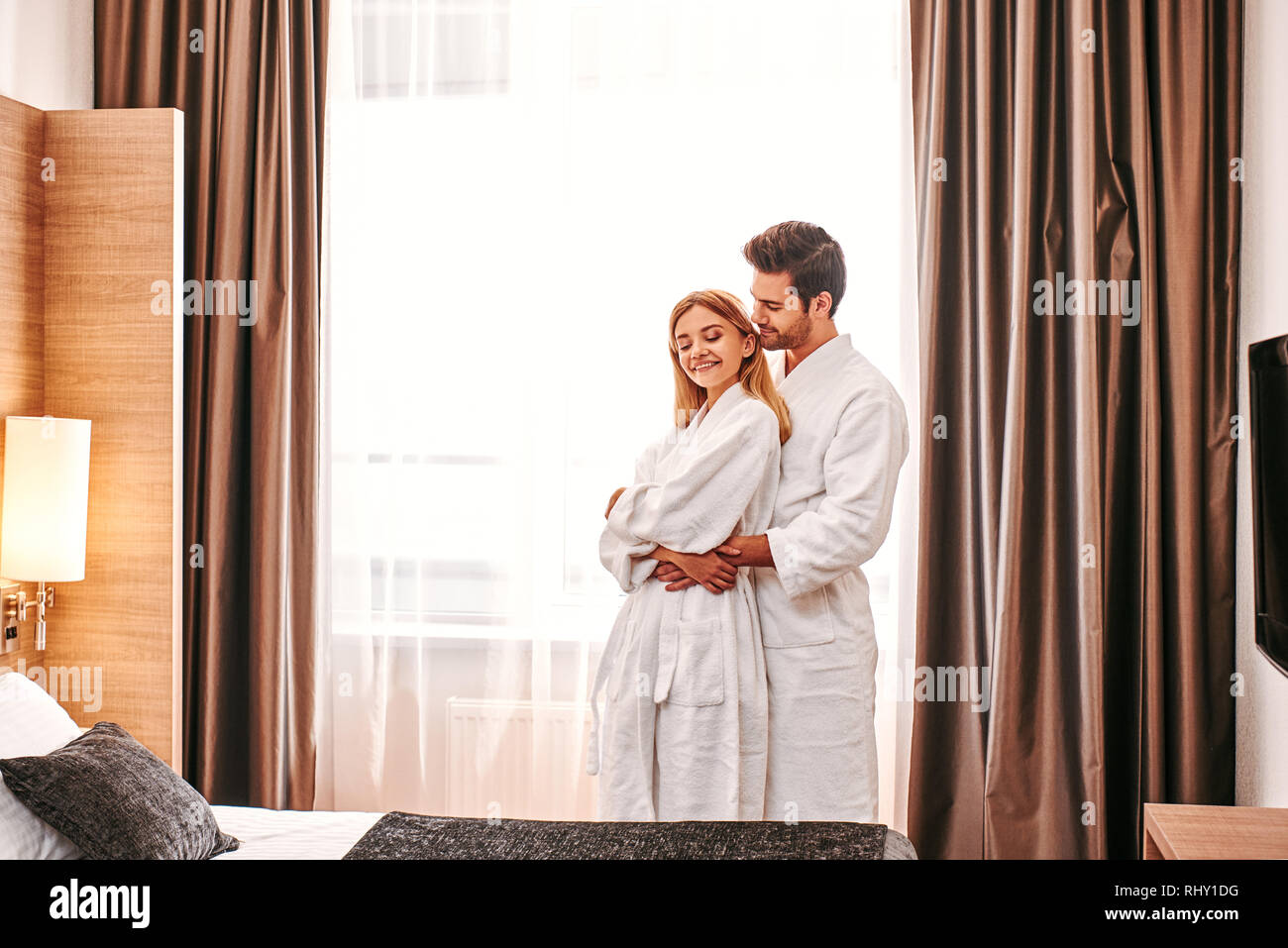 Honeymoon in hotel. Young couple travel together hotel room leisure. Young lovers at hotel room, romantic moments Stock Photo