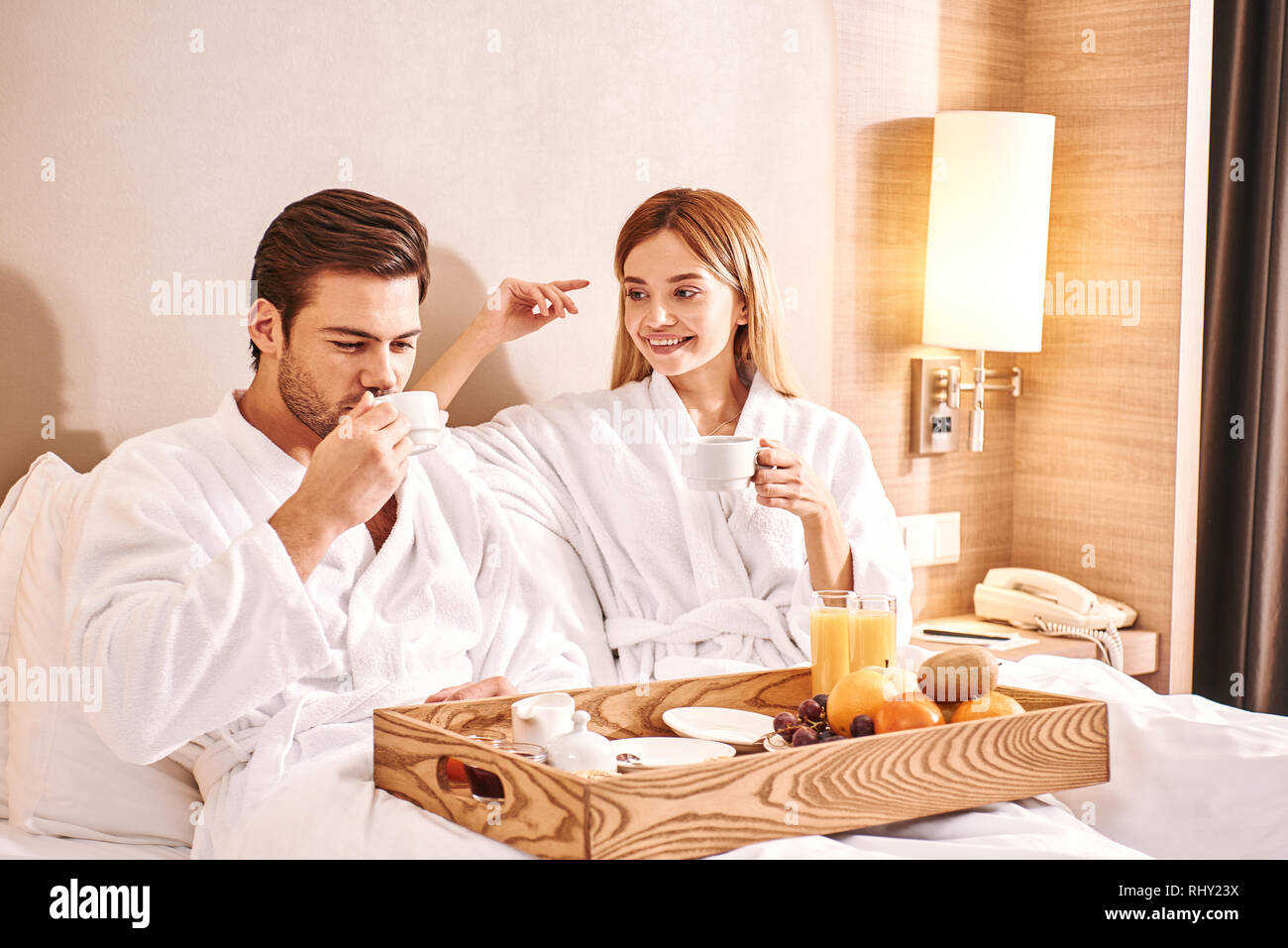Drinking morning coffee in hotel room. Couple are eating in hotel room