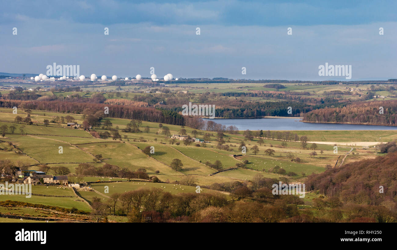 View over scenic sunlit countryside farmland pastures, Fewston reservoir & RAF Menwith Hill domes - Washburn Valley, North Yorkshire, England, UK. Stock Photo